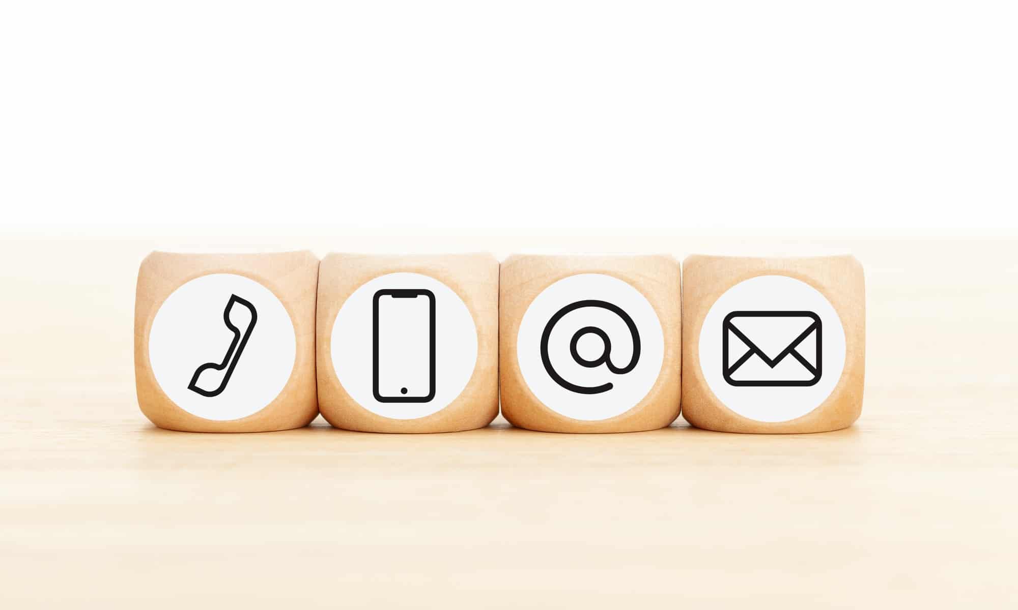 Contact us icons in wooden blocks on wooden desk